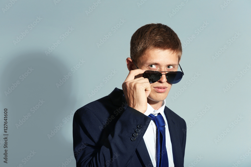 Portrait of elegant man in sunglasses on grey background Portrait of elegant man in sunglasses on grey background