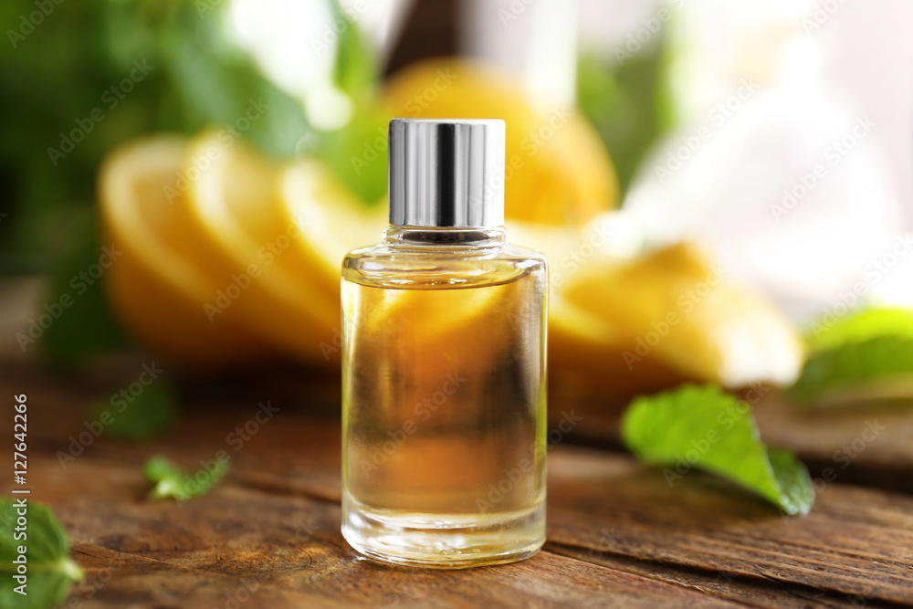 Essential oil with mint and lemon on wooden table Essential oil with mint and lemon on wooden table