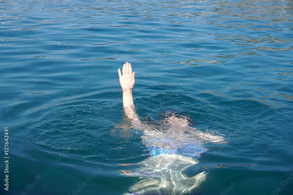drowning in the sea and waving hand for help