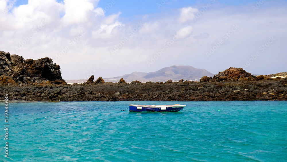 Lagoon with boat and volcanic rocks on Lobos.