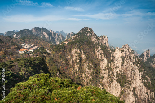 Pine trees on cliff edge, Huangshan Mountain Range in China. Anhui Province - Scenic landscape with steep cliffs and trees during a sunny day. © studiolaska
