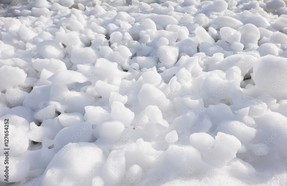 Obraz premium Lumps of snow and ice frazil on the surface of the freezing rive