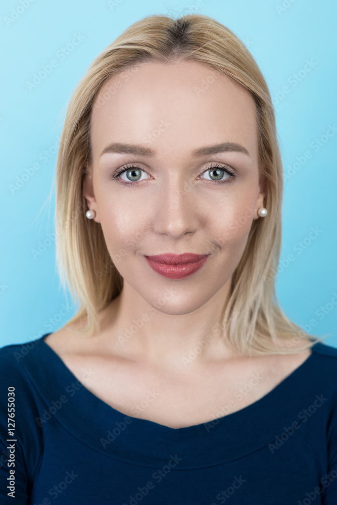 Obraz premium Smiling young blond hair woman looking at camera while standing