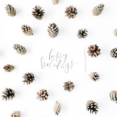 words happy holidays and minimal creative cone arrangement pattern on white. flat lay, top view. christmas background wallpaper.