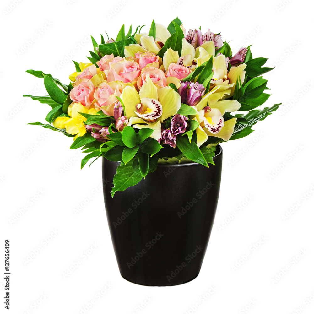 Floral bouquet of roses, lilies and orchids arrangement centerpiece in black vase isolated on white background. Closeup.