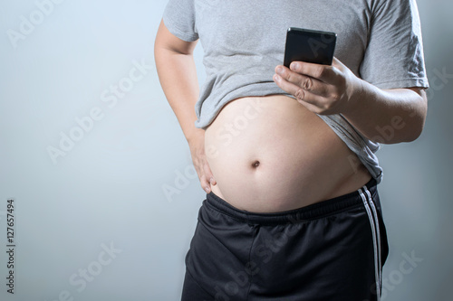 portrait of a asian fat man using mobile phone with show out his photo