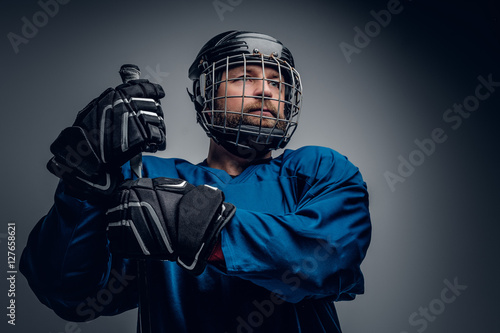 Photography Bearded ice-hockey player in safety helmet holds the gaming stic
