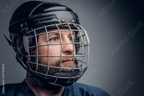 Close up portrait of ice-hockey player in safety helmet.