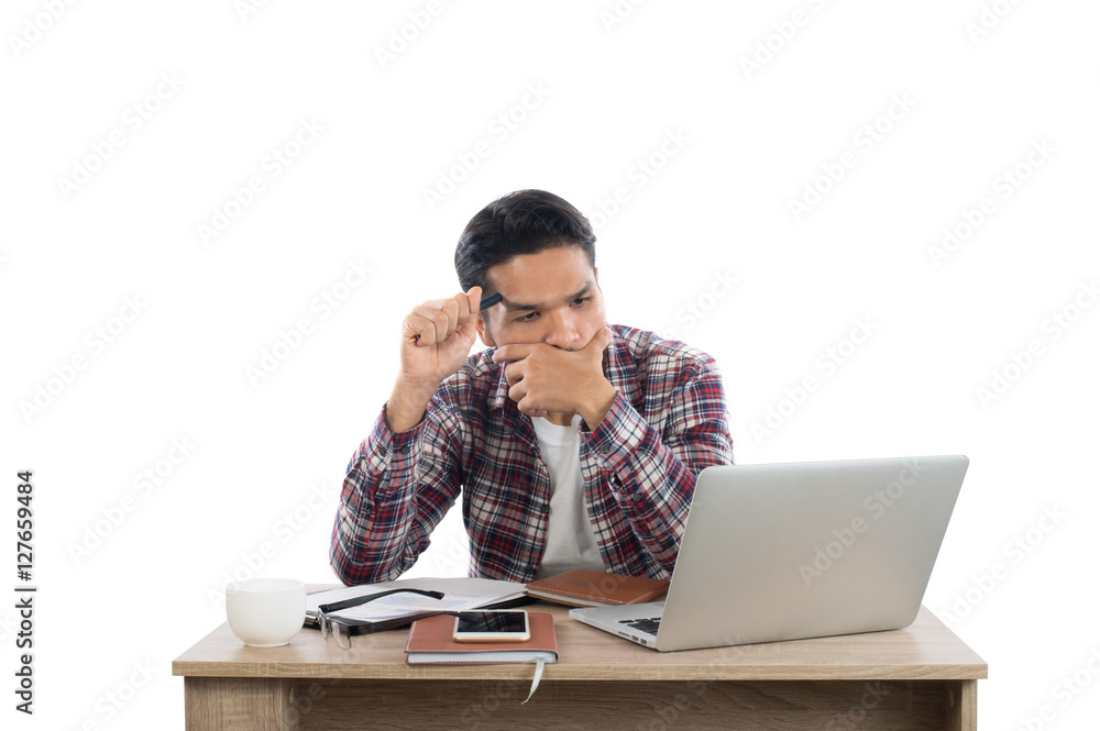 Thoughtful young man holding pen looking at notepad while sittin Thoughtful young man holding pen looking at notepad while sittin