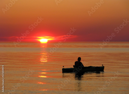 Kayaker watches a beautiful sunset over Lake Superior