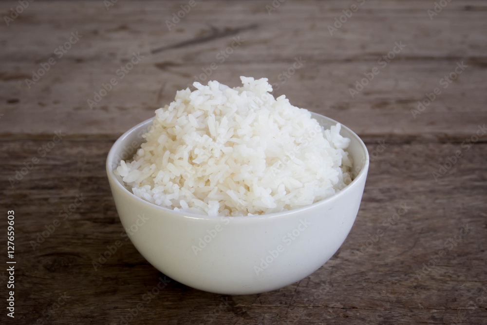 raw jasmine rice in white bowl on wooden table top raw jasmine rice in white bowl on wooden table top