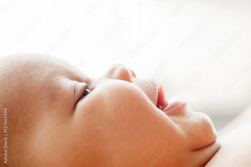 Naklejka premium Profile of newborn baby smiling face, free space. Portrait of little cute adorable child. Childhood, innocence, infant, happy family concept