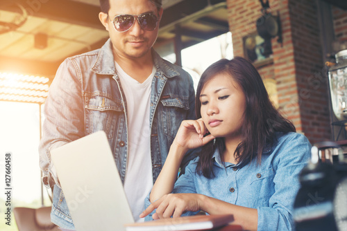 Business couple work with laptop together at cafe.