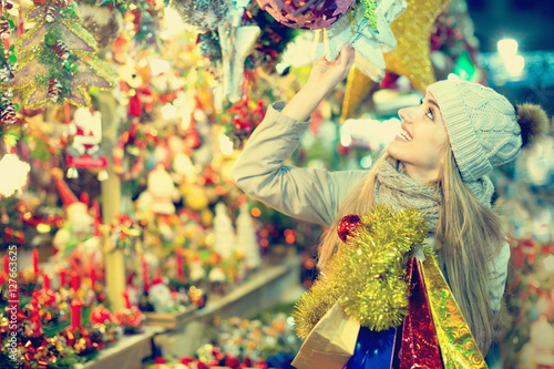 Beautiful smiling woman choosing Christmas decoration