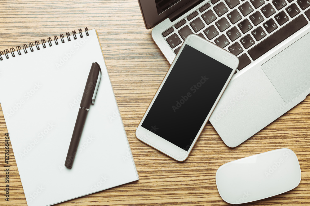 Office table with smartphone on it. View from above Office table with smartphone on it. View from above