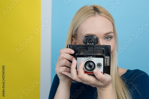 Girl taking photo on retro vintage hipster camera