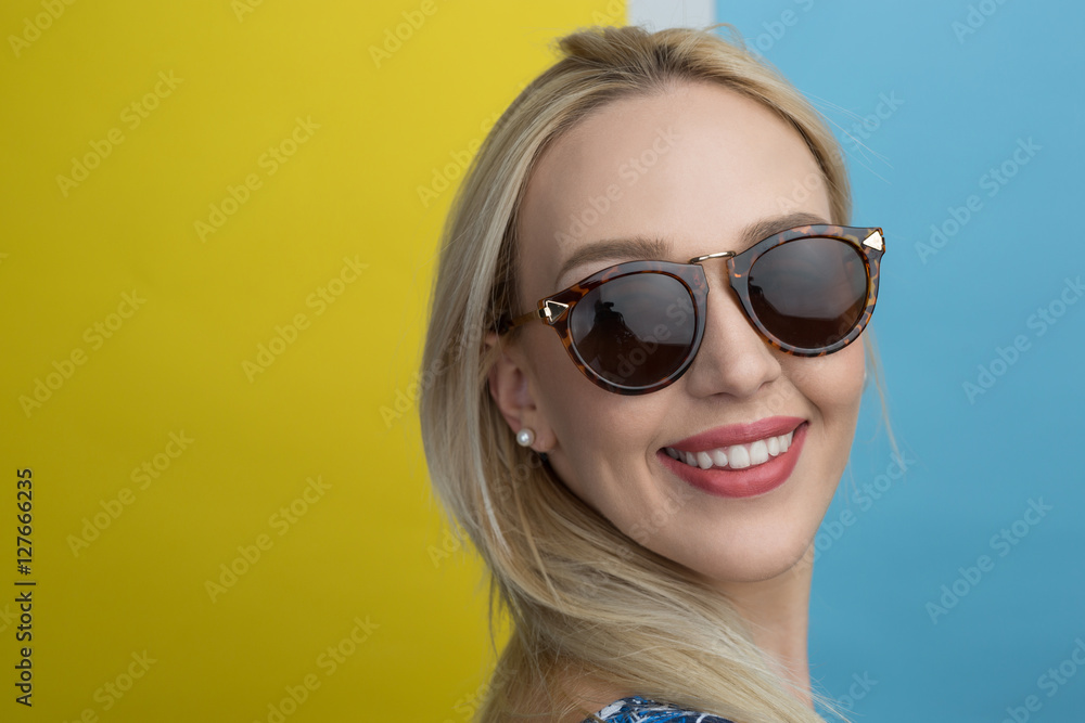 Young woman smiling with beautiful blond hair over color backgro Young woman smiling with beautiful blond hair over color backgro