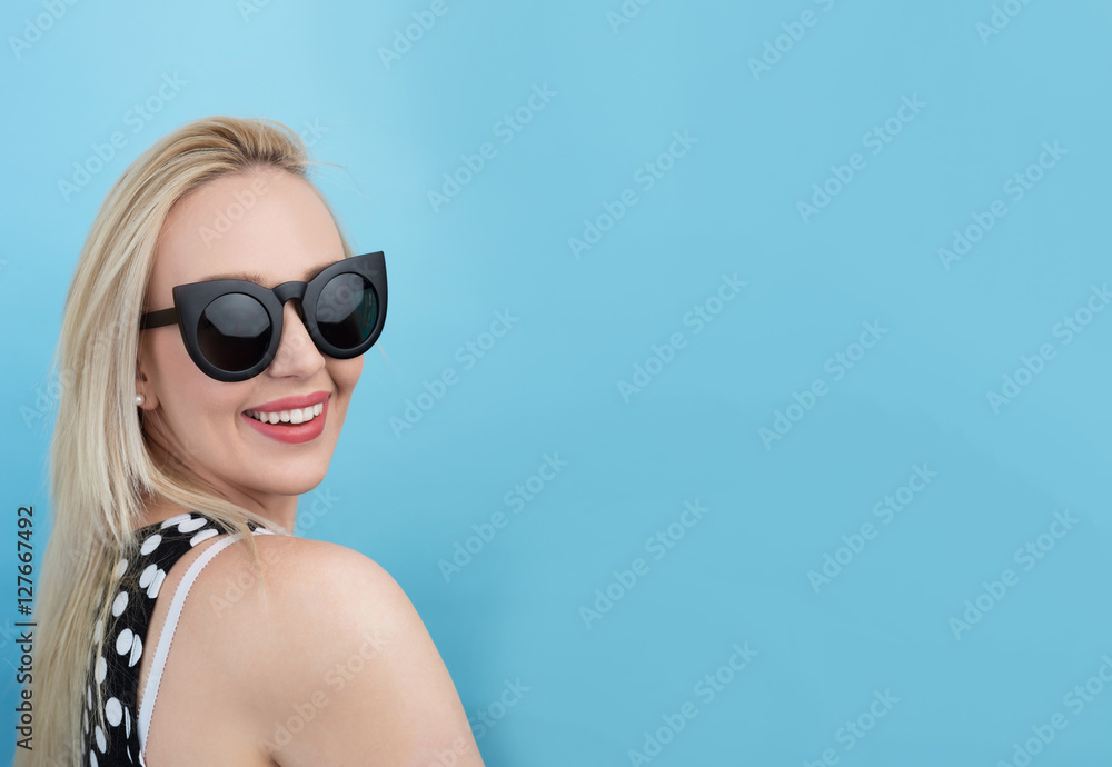 Smiling young blond hair woman looking at camera while standing Smiling young blond hair woman looking at camera while standing