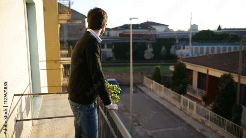 Boy is watching a train passing out of his balcony Boy is watching a train passing out of his balcony