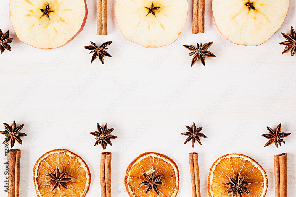 Christmas food - mulled wine background. Decorative frame of spice ingredients - anise stars, cinnamon, dried oranges and wine on wood white surface. Top view. Christmas food - mulled wine background. Decorative frame of spice ingredients - anise stars, cinnamon, dried oranges and wine on wood white surface. Top view.