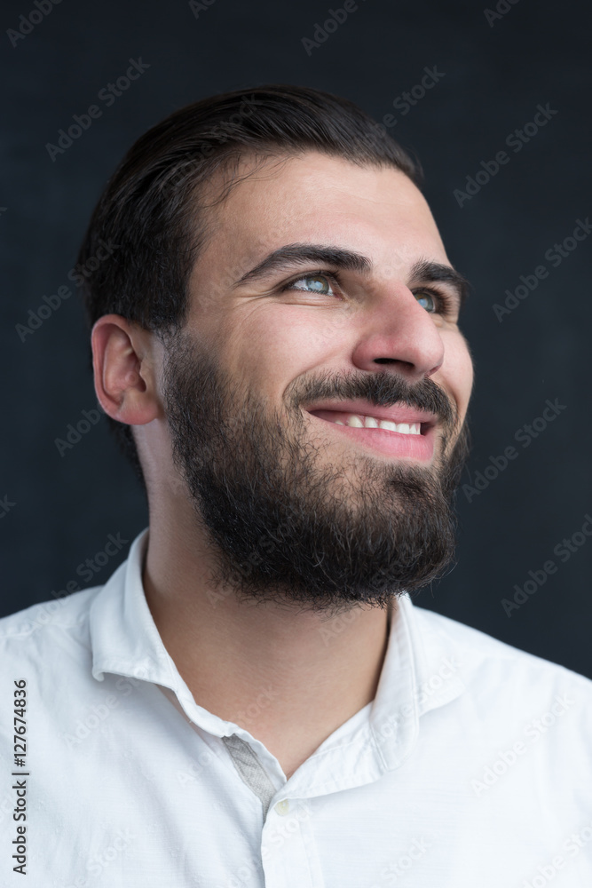 Obraz premium Portrait of a young bearded man against black chalkboard