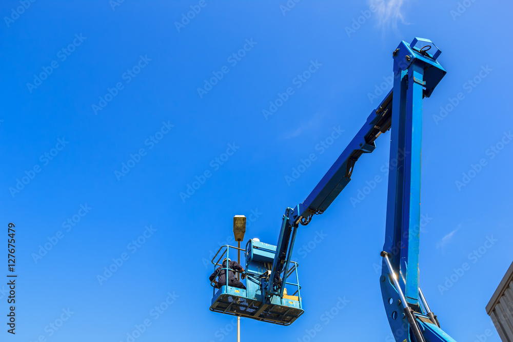 Electrical technician repairing street light by boom lift Electrical technician repairing street light by boom lift