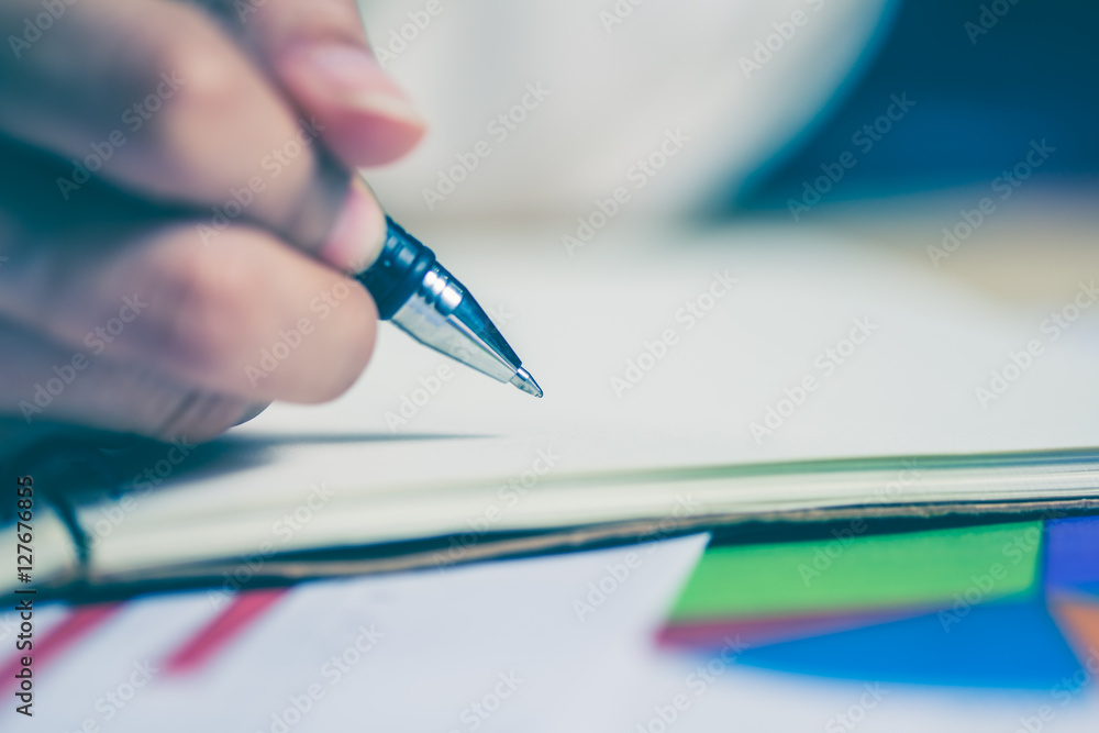 Business women hands working writing notebook on wooden desk, lighing effect Business women hands working writing notebook on wooden desk, lighing effect