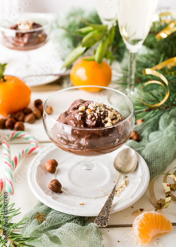 Chocolate pudding mousse with avocado, nuts and christmas decorations. Delicious Christmas themed dinner table.