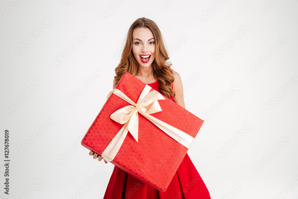 Woman in santa claus dress giving you big red gift Woman in santa claus dress giving you big red gift
