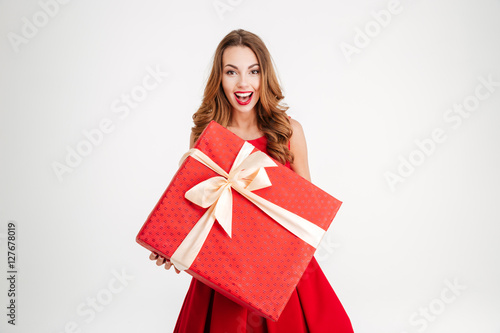 Woman in santa claus dress giving you big red gift