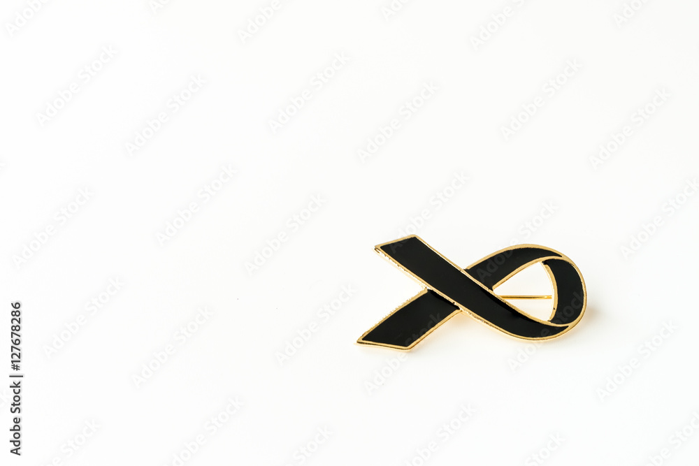 Condolences black ceramic ribbon on the pin with the wooden background. To show the sorrow with the grief on the passing of people. These ribbons can be pinned on shirts or clothes. Condolences black ceramic ribbon on the pin with the wooden background. To show the sorrow with the grief on the passing of people. These ribbons can be pinned on shirts or clothes.