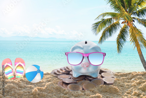 travel piggy bank with sunglasses relax on the beach holiday. concept saving money for travel in holiday