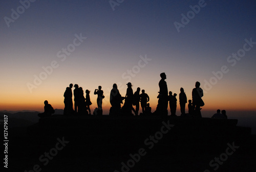 Silhouette of a group of people at sunset .