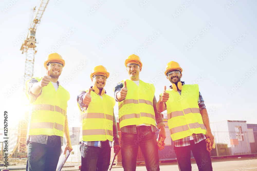 group of smiling builders with tablet pc outdoors group of smiling builders with tablet pc outdoors