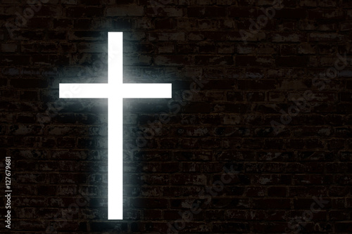 Glowing cross on a brick wall