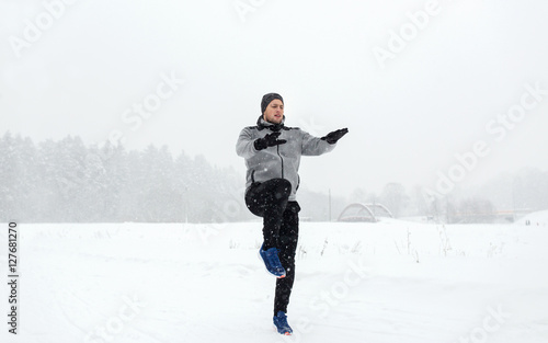 man exercising and warmig up in winter outdoors