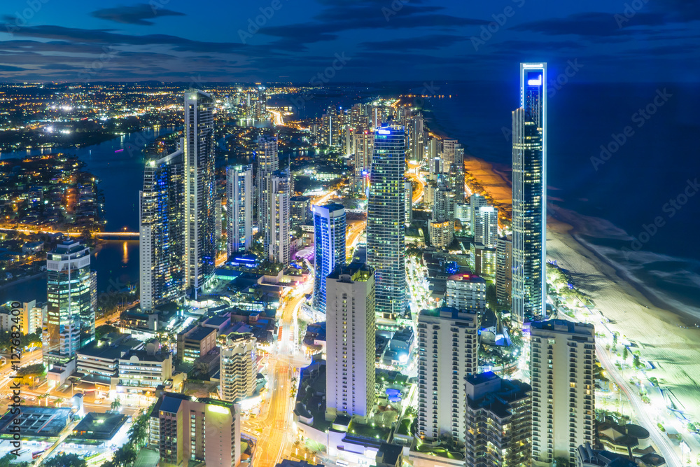 Obraz premium Illuminated modern buildings near the beach at night