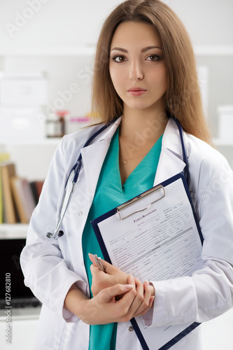 Portrait of female doctor holding patient registration form photo