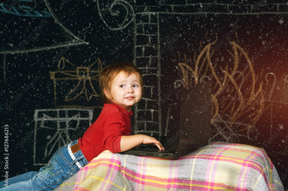 Naklejka premium Little kids with laptop on a Christmas background . A Letter To Santa Claus