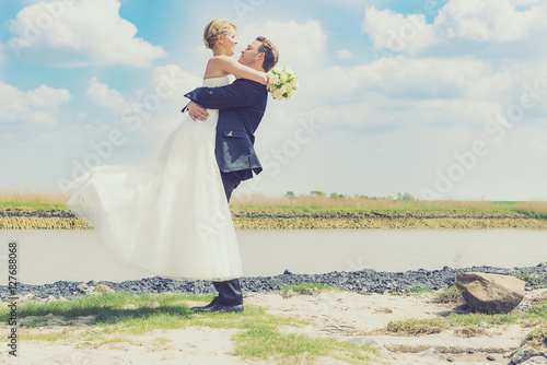 Bräutigam hält Braut in die Luft - Flitterwochen