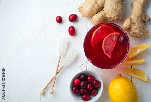 Fresh cranberry juice with lemon, berry, ginger and sugar on a light background. Top view. Space for text. Selective focus.