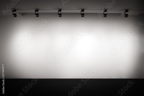 White gallery wall with light, empty white wall, interior background, presentation wall, empty showcase