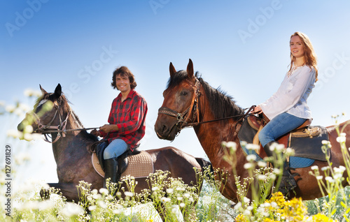 Portrait of young couple horseback riding