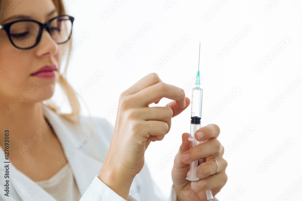 Female doctor holding a large intramuscular syringe. Female doctor holding a large intramuscular syringe.
