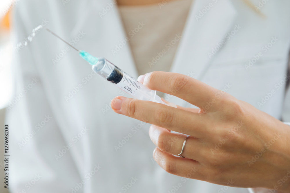 Female doctor holding a large intramuscular syringe. Female doctor holding a large intramuscular syringe.
