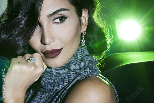 beautiful woman looking right with golden earring and ring