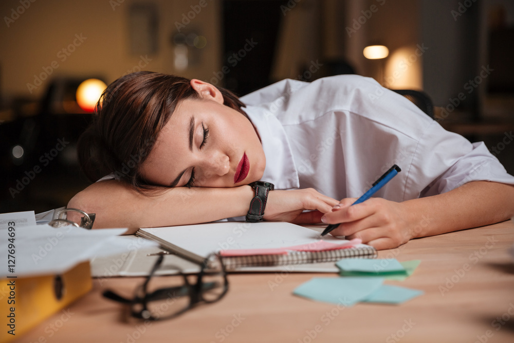 Tired exhausted young businesswoman sleeping in office Tired exhausted young businesswoman sleeping in office
