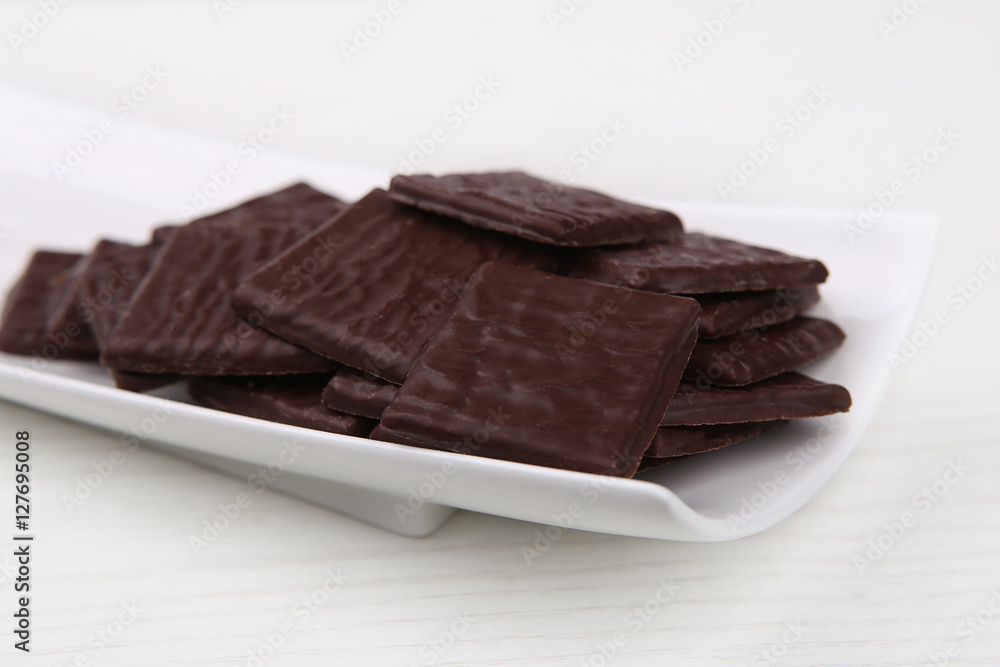 Dark Squares Chocolates. Chocolates in white plate. Dark Squares Chocolates. Chocolates in white plate.