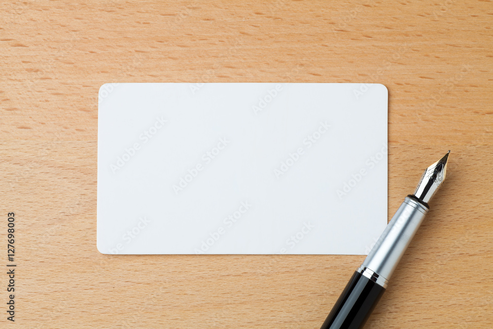 Blank business card and fountain pen on the wooden table Blank business card and fountain pen on the wooden table