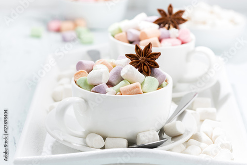cocoa with colorful marshmallows and spices in cups